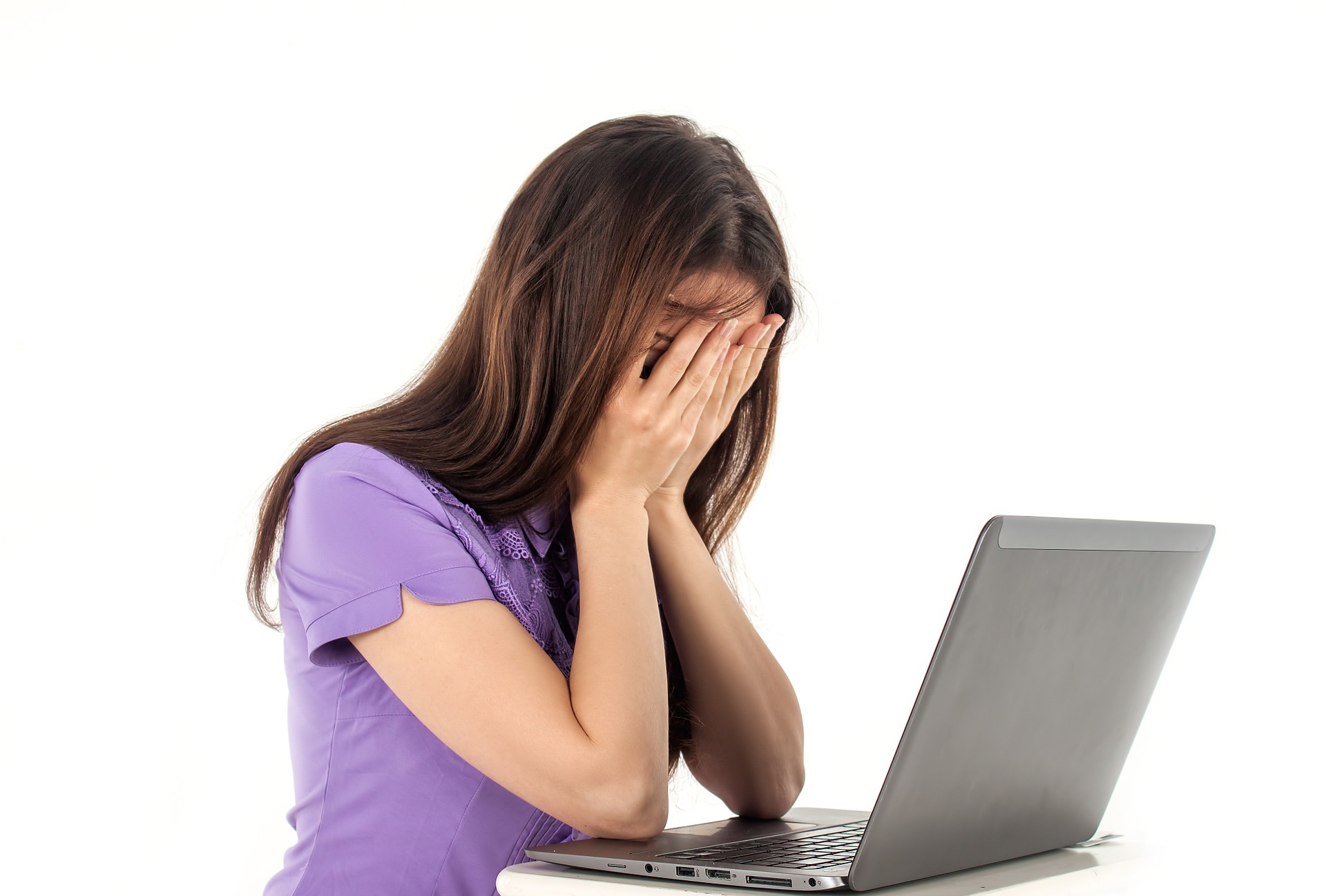 Girl with hands on her face with a laptop